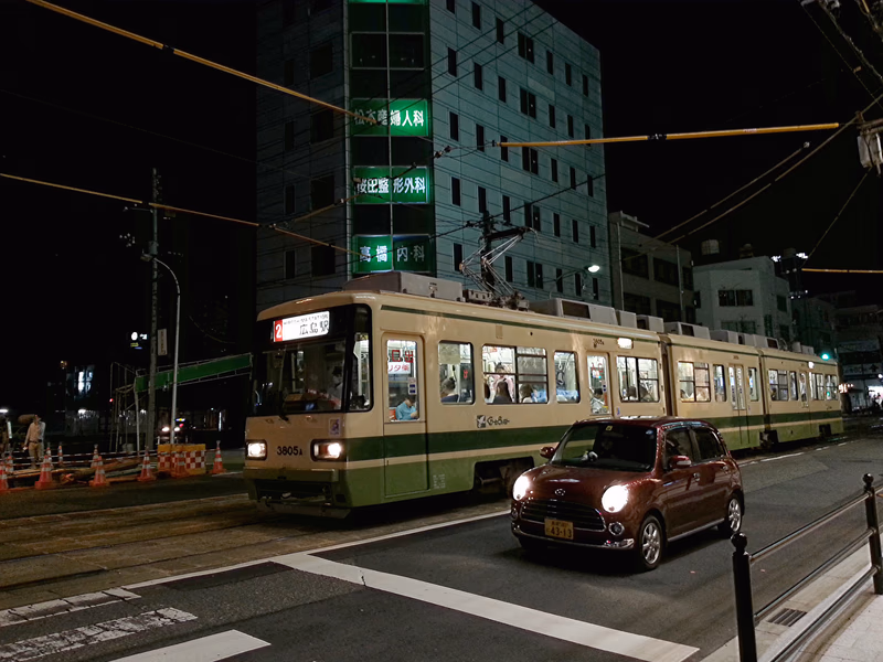 A tram travels through a city at night.