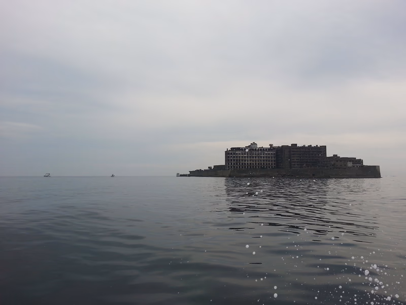 A small island with a large building in the middle of the water.