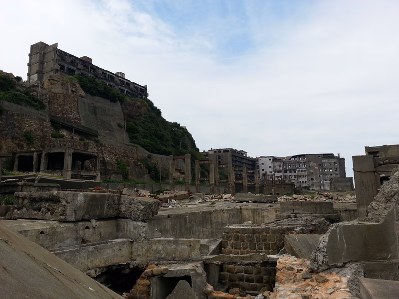 A photo of a coastal area with old buildings and a partially destroyed structure.
