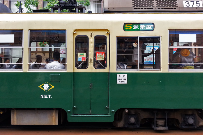 A vintage train car with cream and green paint features a sign reading "5堂茶屋" and the number "375" on the side.