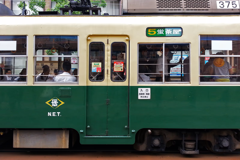 A photograph of a bus in a city, showing passengers and the interior.