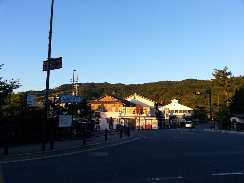 A view down a street in a town with several low-rise buildings, including one with a sign that reads "仁王門通り".