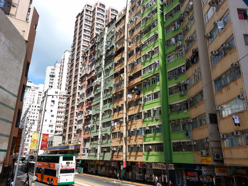 A vibrant street scene in Hong Kong, showcasing the dense urban environment and the daily life of its inhabitants.