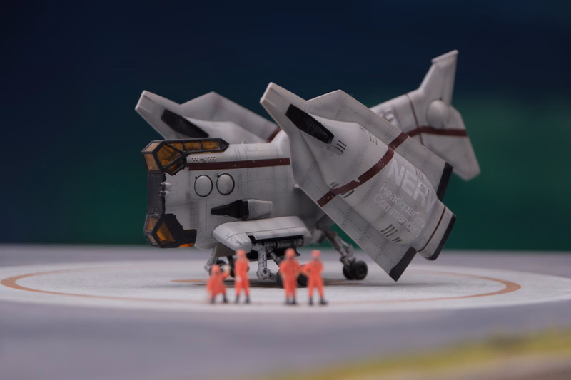 A detailed model of a white spaceship labeled "NERD Headquarters Commander" is displayed on a circular platform with small figures nearby.