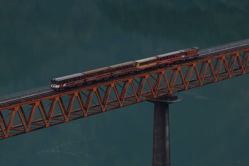 A model train set on a bridge over a body of water.