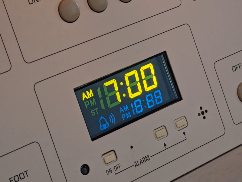 A digital alarm clock displays the time as 18:00, with settings for AM, PM, and ST.