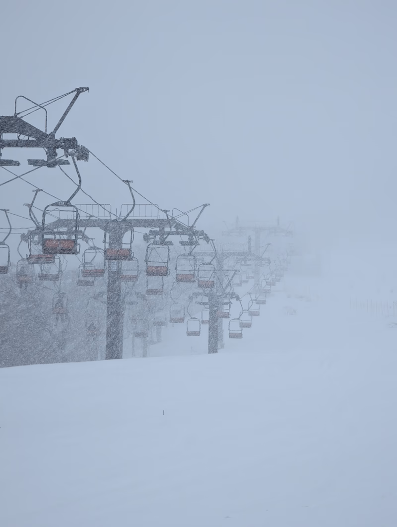 A photo of a ski lift in a snowy landscape.