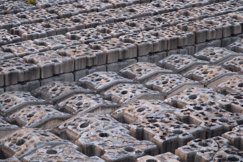 A photograph of a large number of cement blocks arranged in a field.
