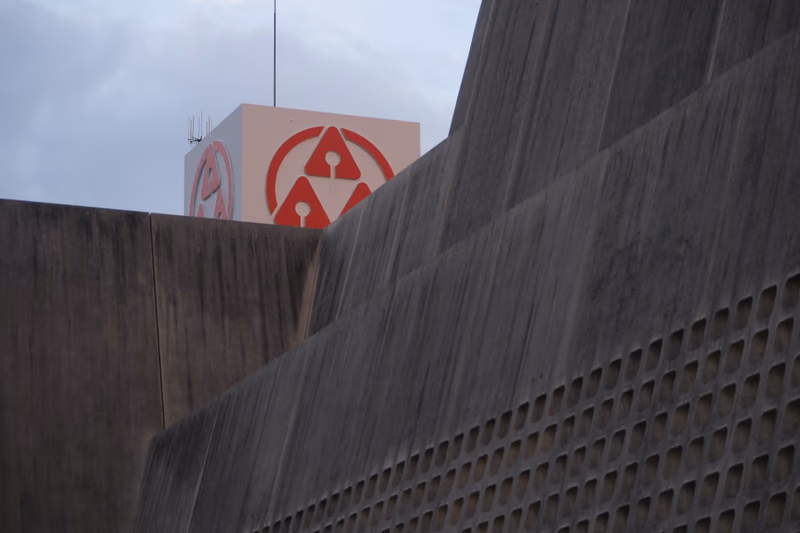 A photo of a building with a logo on top.