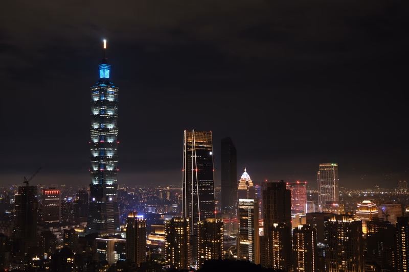 A night view of Taipei's skyline with the illuminated Taipei 101 and other buildings.