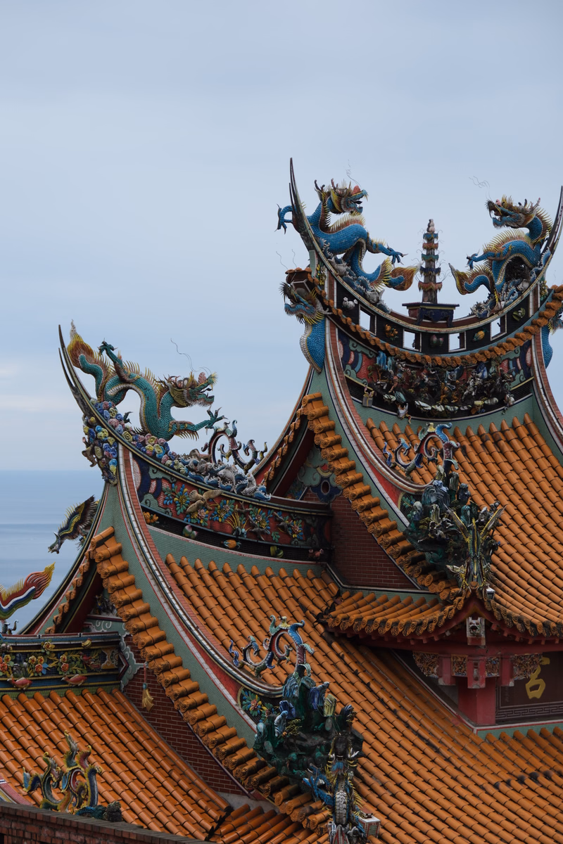 Ornate, multi-tiered pagoda roofs featuring colorful dragon sculptures against a pale sky.