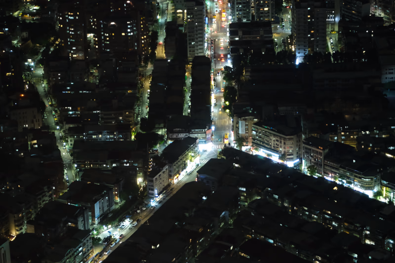 The photo shows a city at night with illuminated buildings and streets.