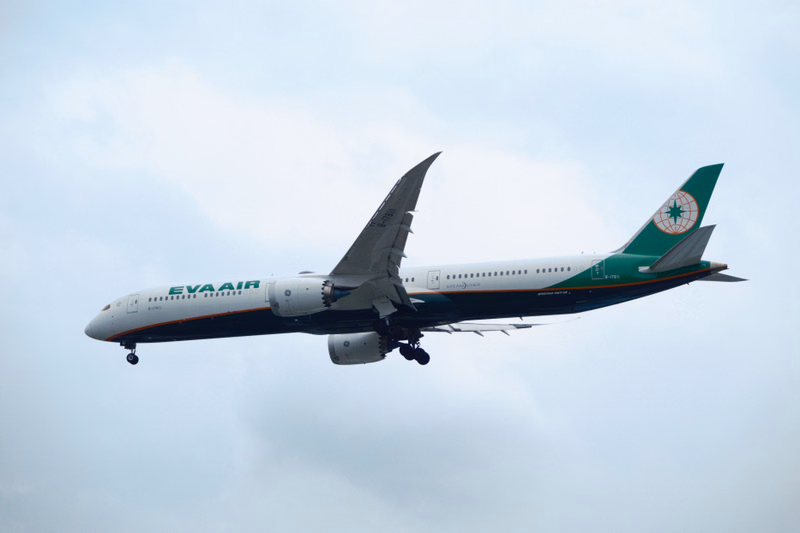 An EVA Air airplane is taking off against a cloudy sky, with the text "EVA AIR" visible on the fuselage.