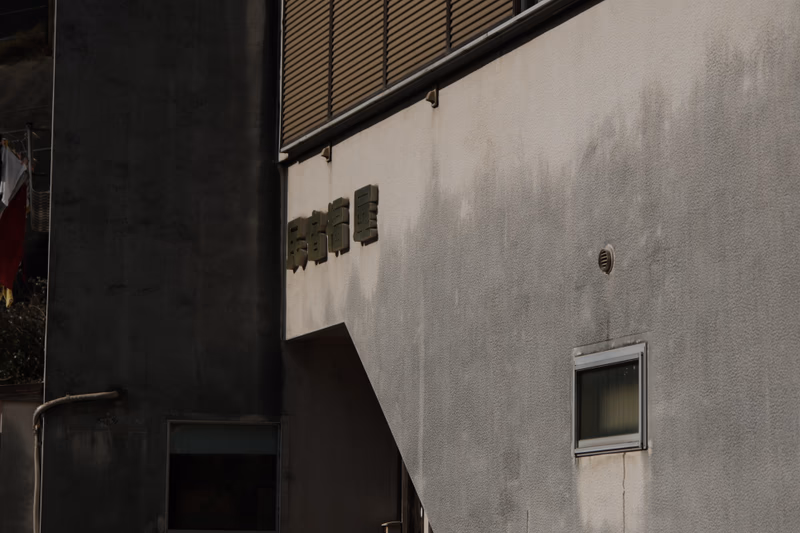 A photo of a building with Japanese characters and a small window.