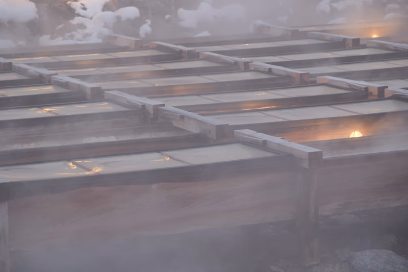 A wooden structure covered with snow, illuminated by a light source.