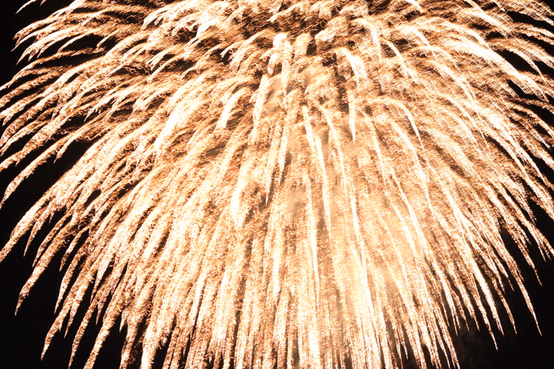 A photograph of fireworks exploding in the night sky over Oshino, Yamanashi, Japan.
