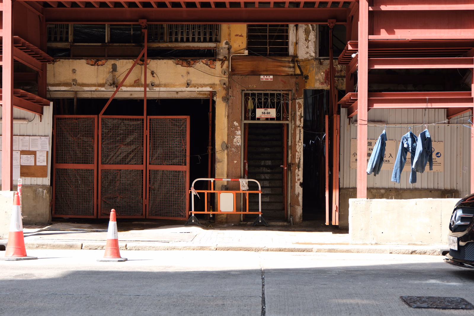 An old, weathered industrial storefront with large metal roll-up doors and a sign reading "58-60" above the entrance.