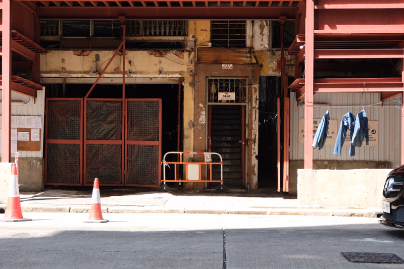An old, weathered industrial storefront with large metal roll-up doors and a sign reading "58-60" above the entrance.