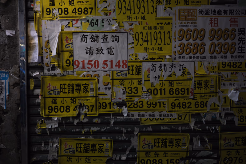 A wall covered in license plates and posters, with a mix of English and Chinese text.