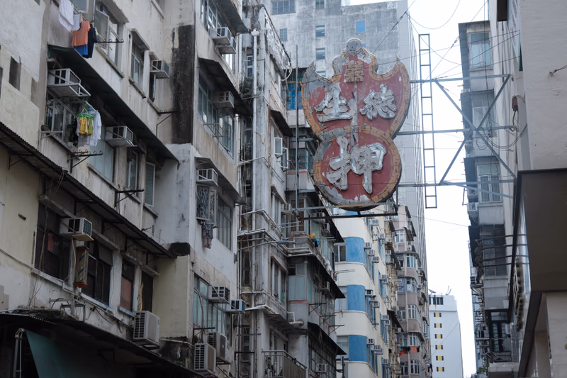A signboard in a densely packed urban area of Hong Kong.