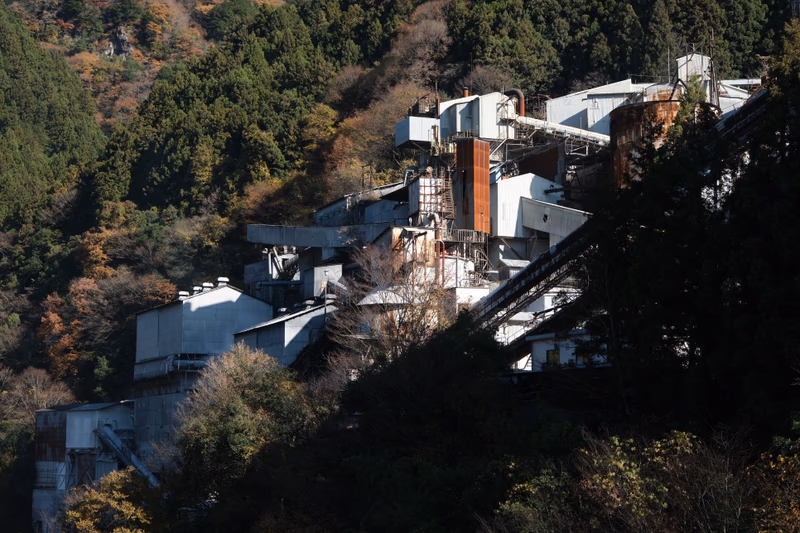 A photo of an industrial complex surrounded by a forest and mountains in Itsukaichi, Tokyo, Japan.