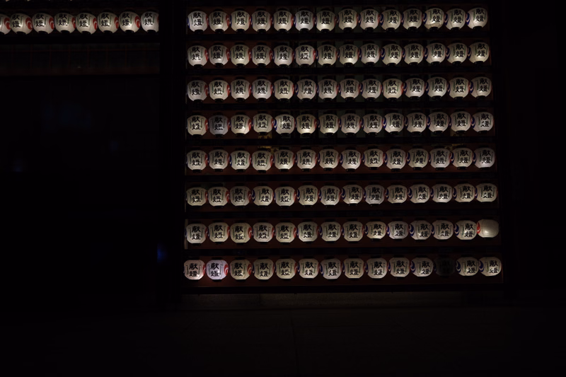 A display of multiple rows of wooden prayer beads, or mala, arranged on a dark surface.