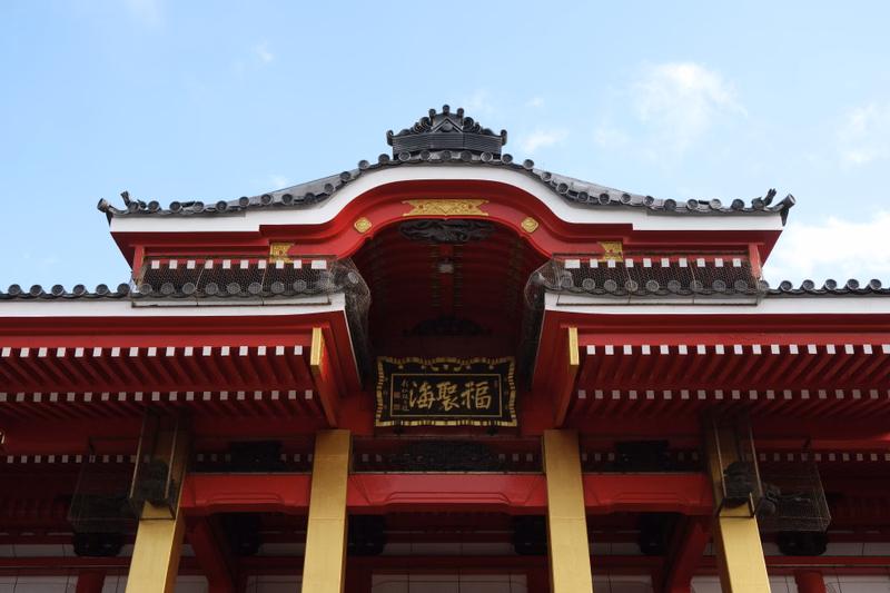 A traditional Chinese temple building with a dark tiled roof and red and white facade, featuring a sign that reads "弘福堂".