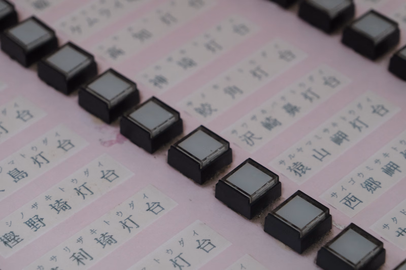A close-up of a set of black chopsticks with labels in Japanese, including text like "島崎打刀" and "沢崎昇打刀".