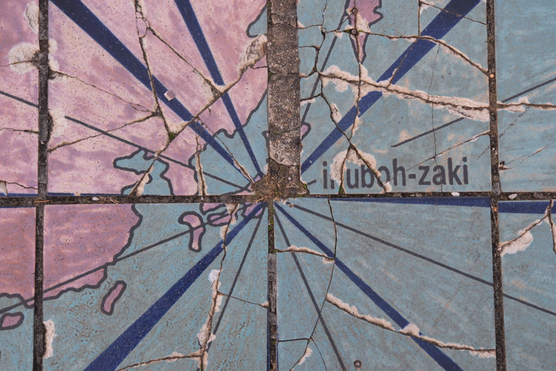 A close-up of a tiled surface with a cracked pattern and the text 'I. uboch-zaki' in the corner