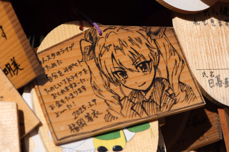 A hand-drawn portrait of an anime-style character on a light brown wooden plaque, with Japanese text that reads "2025.3.7 桜岡菜々".