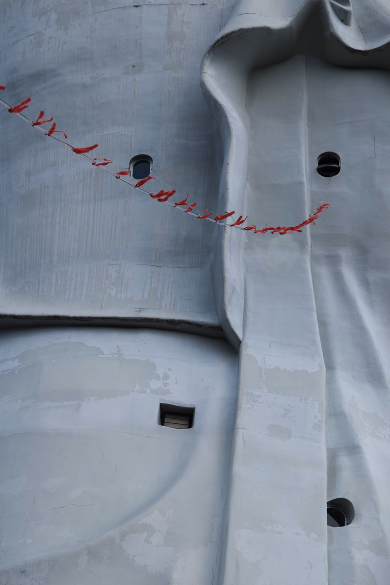 A white building facade features a decorative red rope strung across the curved architectural details.
