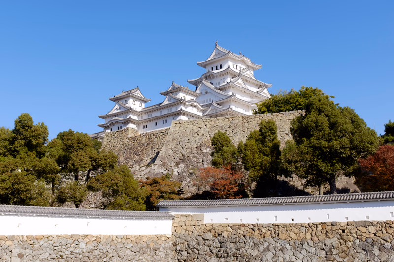A photo of the Himeji Castle, a UNESCO World Heritage Site, located in Himeji, Hyōgo, Japan. The castle is a prime example of Japanese castle architecture and is surrounded by lush greenery.