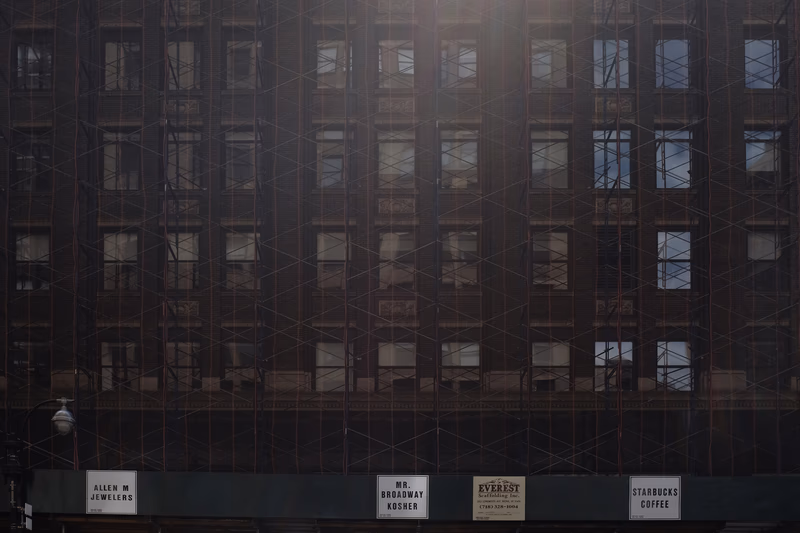 A photo of a building facade with signage and window reflections, taken near Times Square, New York, United States.