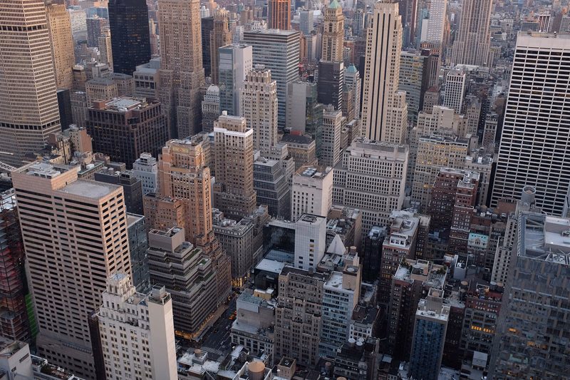 A dense urban cityscape view showing numerous tall skyscrapers and buildings packed closely together in a metropolitan area.