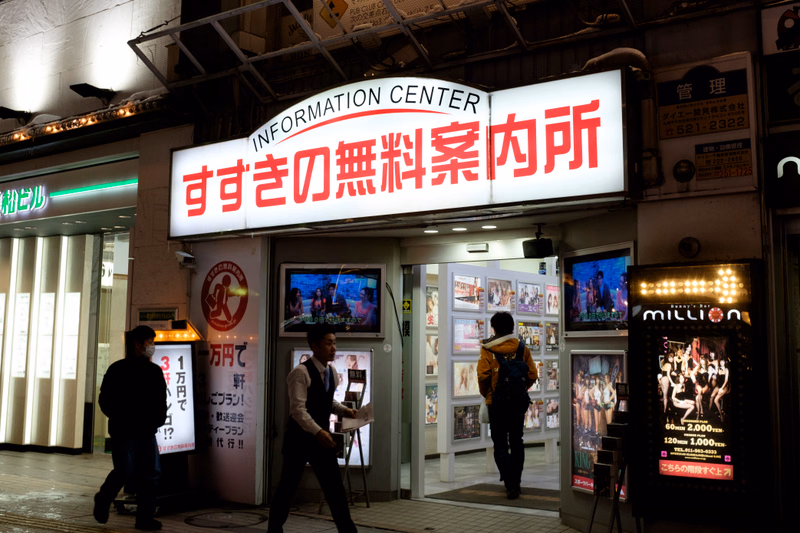A storefront with a large sign reading "INFORMATION CENTER すき家の無料案内所" is visible at night.