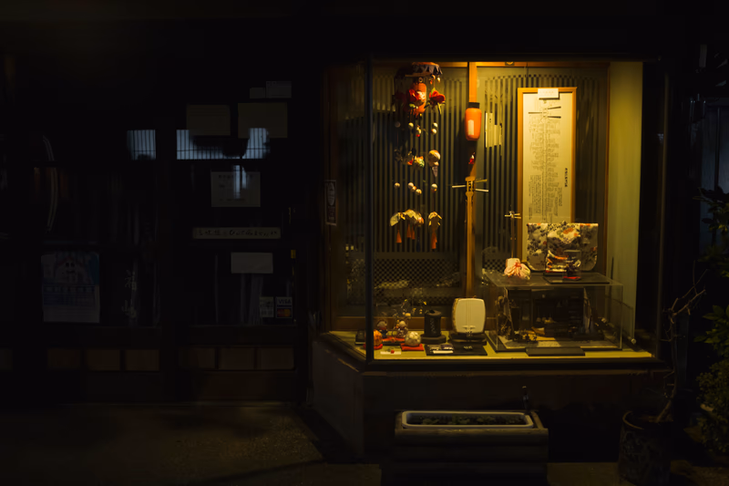 A nighttime view of a storefront with a window display