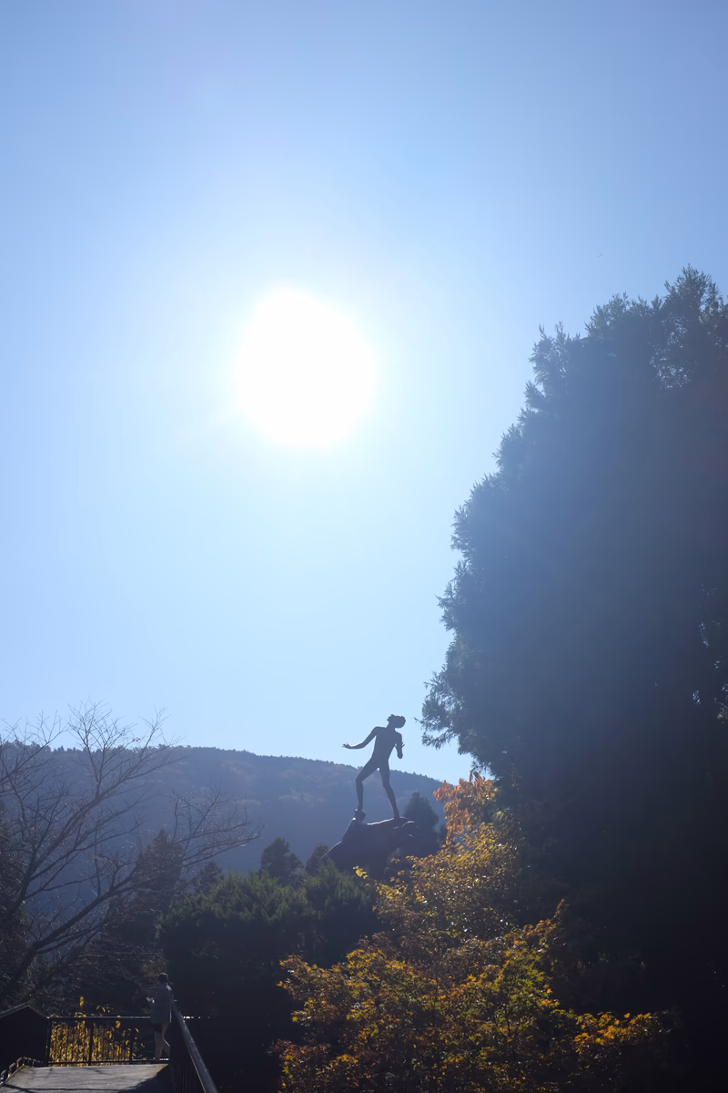 A person jumping off a cliff with a mountain in the background.