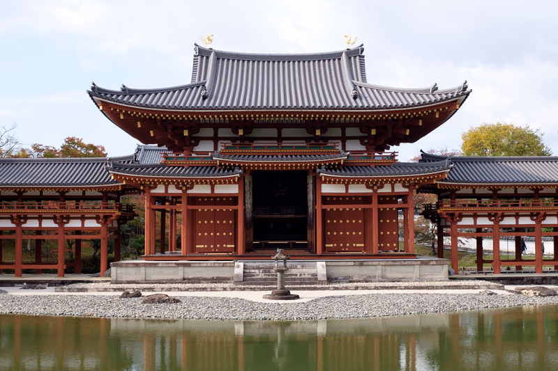 A traditional Japanese building with a serene garden and a pond in front of it.