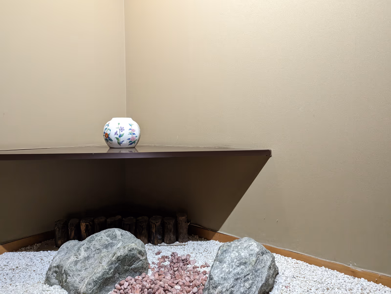 A serene and minimalistic interior with a focus on natural elements and a small white vase.