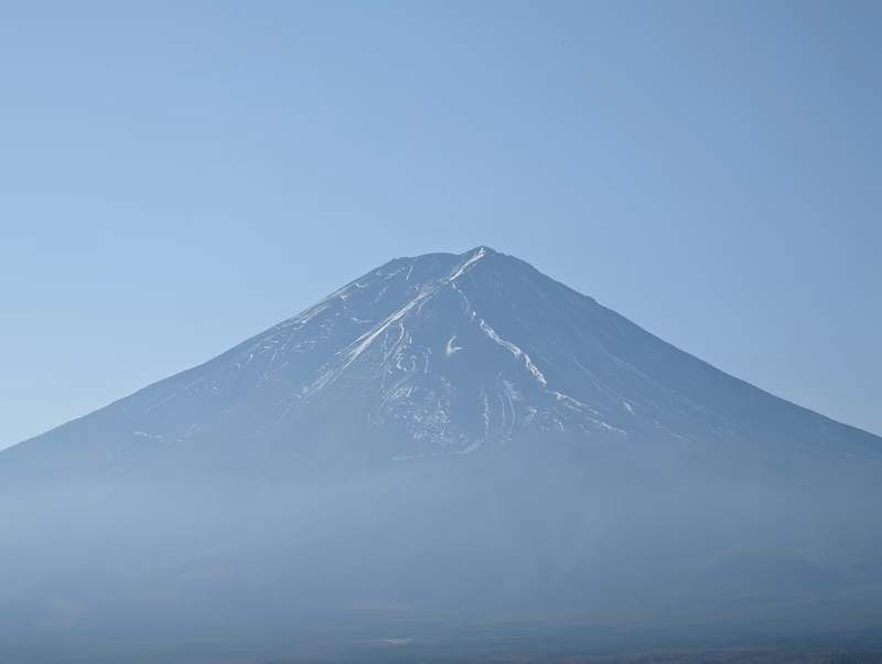 A photograph of a snow-capped mountain with a clear blue sky in the background.