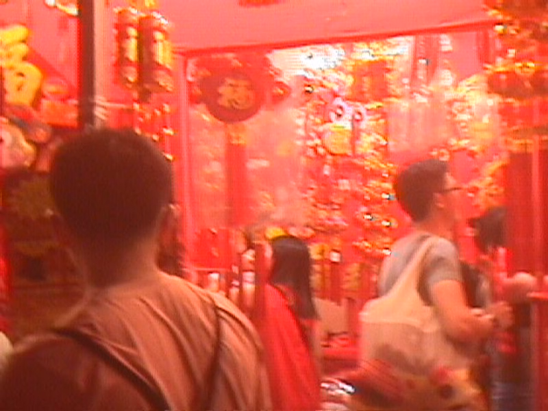 A vibrant indoor market filled with numerous red lanterns and festive decorations, likely for Chinese New Year.