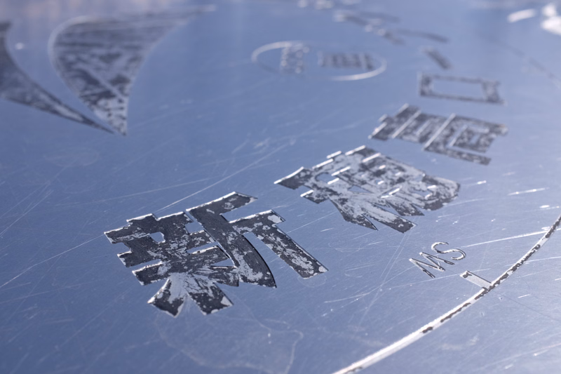 A close-up of a metallic stamp showing Chinese characters and the text "MS 1".