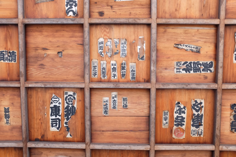 A collection of wooden panels with Japanese characters and shards of wood, likely from a traditional Japanese workshop.