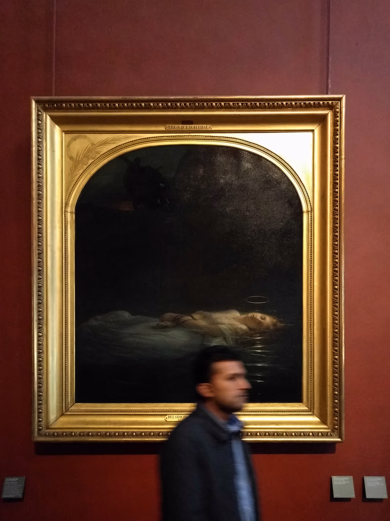 A man walks past a painting in a museum.