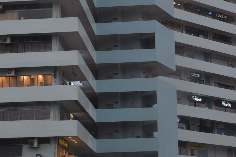 A modern building with a user interacting with it. The text on the building is partially visible and appears to be in English.