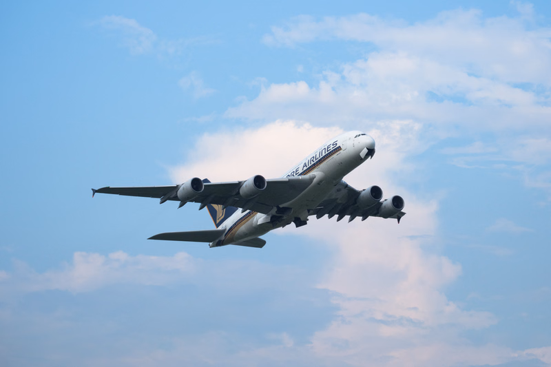 A Boeing 747 airplane belonging to Ore Airlines is seen taking off against a blue sky with scattered clouds.