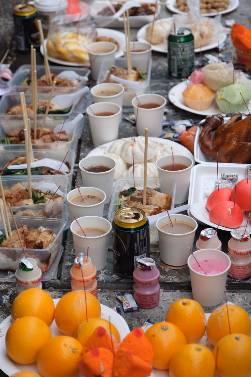 A collection of food items, drinks, and baskets are arranged on a rustic wooden table for a picnic.