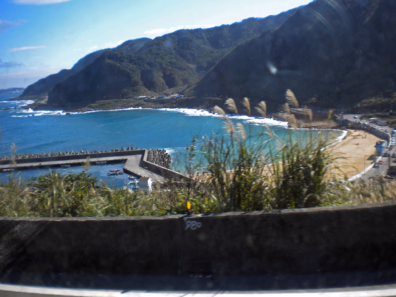 A photo of a coastal landscape with a mountain in the background and a beach in the foreground.