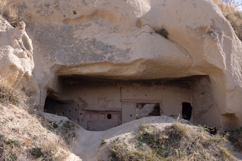 A photo of an ancient cave with carved rock formations inside.