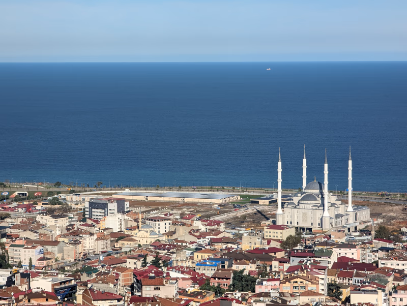 Aerial view of the city of Trabzon, near the sea, with a prominent mosque in the foreground.